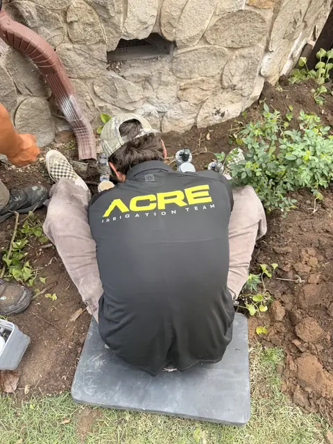 ACRE irrigation tech working on a valve manifold (ACRE job photo)
